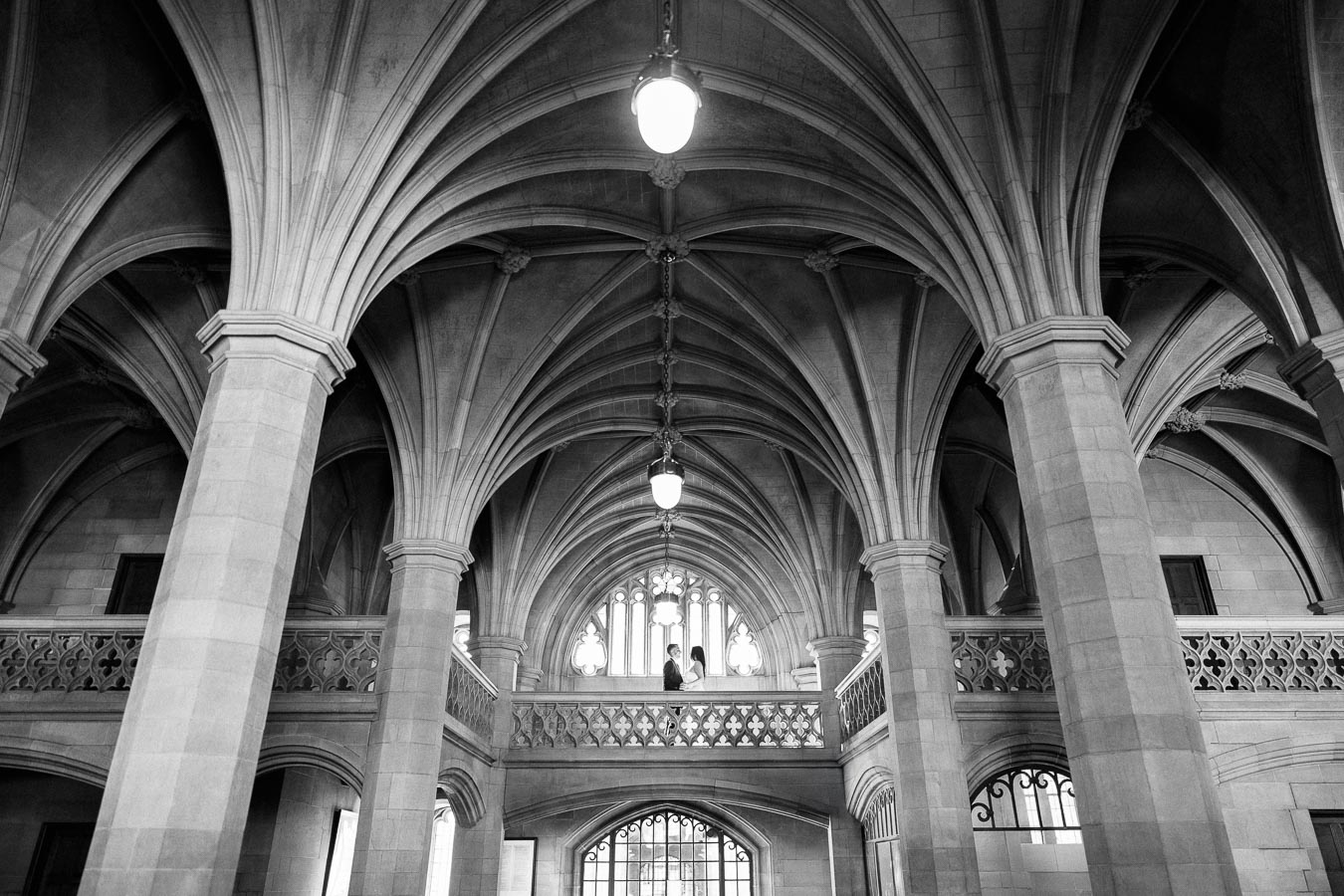 Black and white photo of an ornate Gothic-style cathedral interior, showcasing vaulted ceilings, stone pillars,