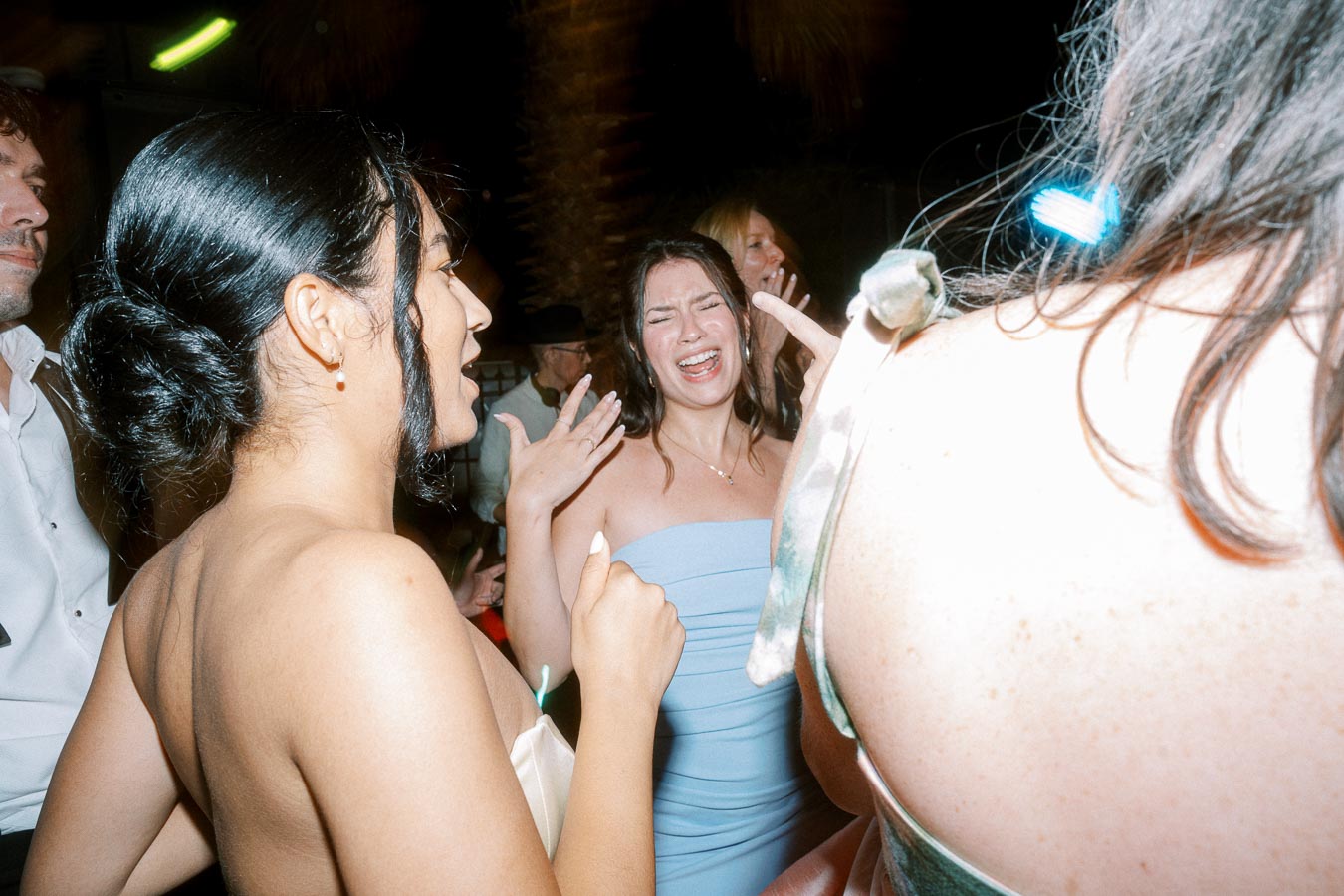 Women joyfully dancing at a lively indoor party, capturing a moment of celebration and happiness.