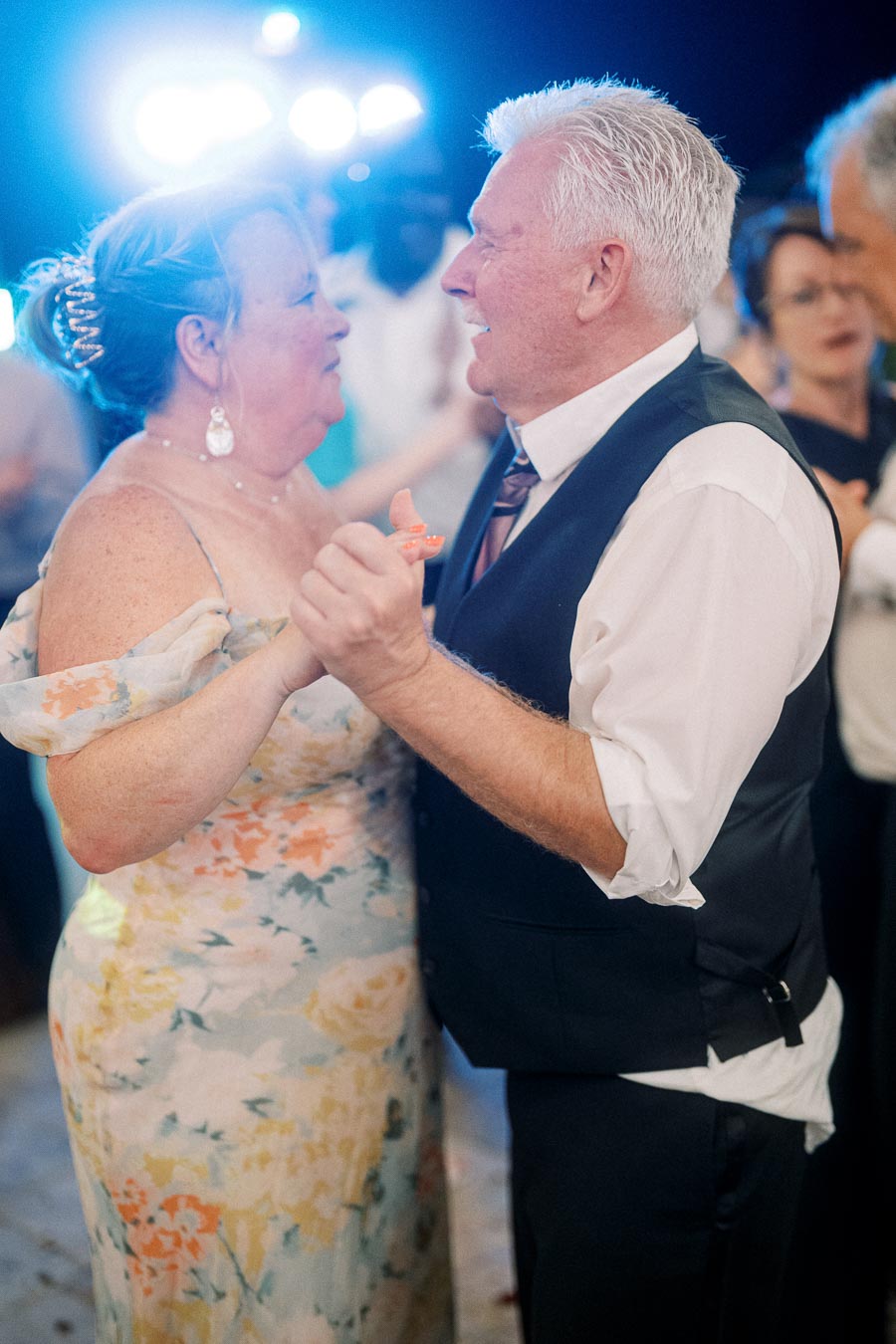 Elderly couple dancing joyfully at a wedding reception, showcasing love and celebration.