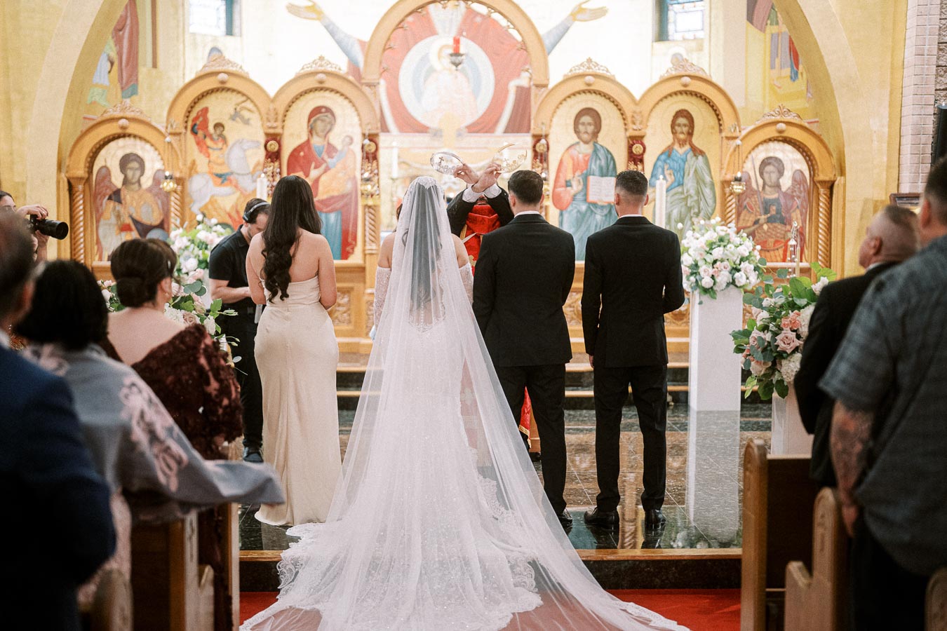 Bride and groom standing at the altar during a traditional church wedding ceremony, surrounded by bridesmaids and groomsmen,