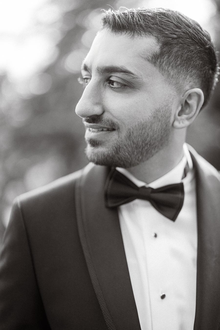 Black and white portrait of a man in a tuxedo, showcasing elegance and sophistication.
