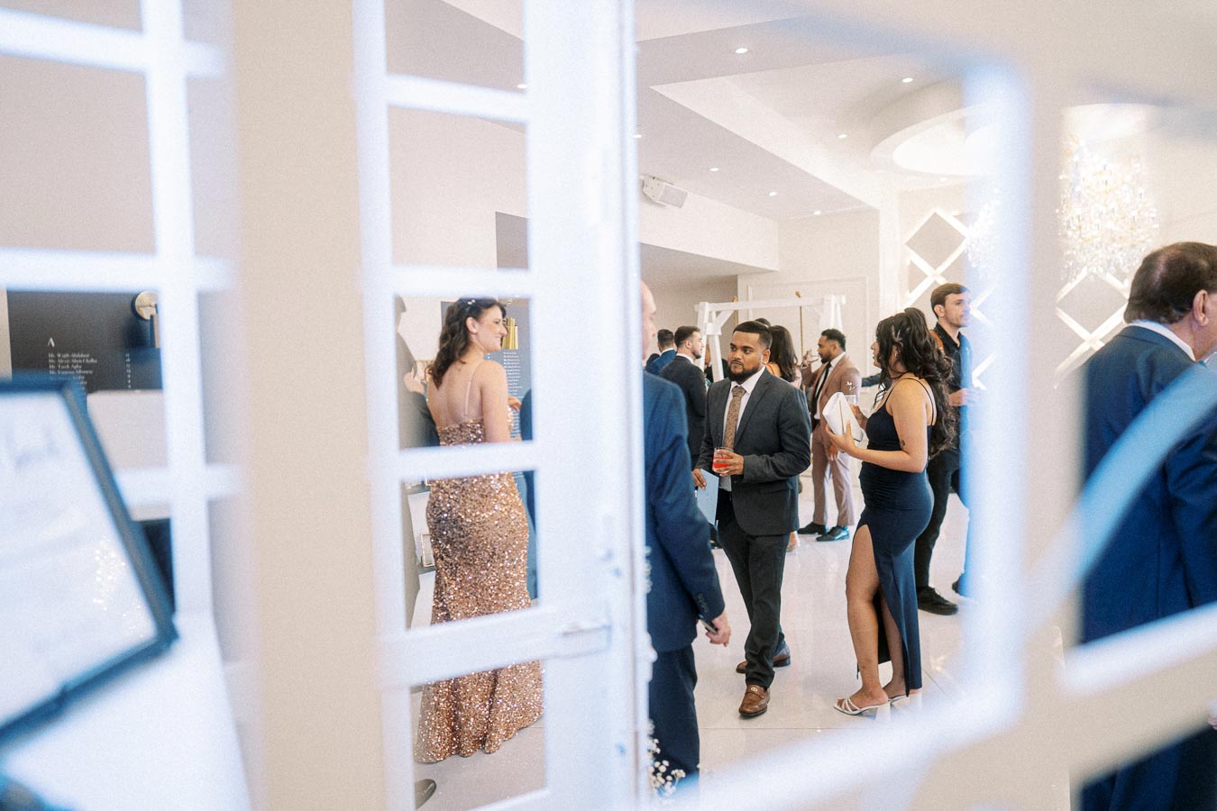 A chic and elegant cocktail party with guests in formal attire socializing in a beautifully decorated venue, featuring soft