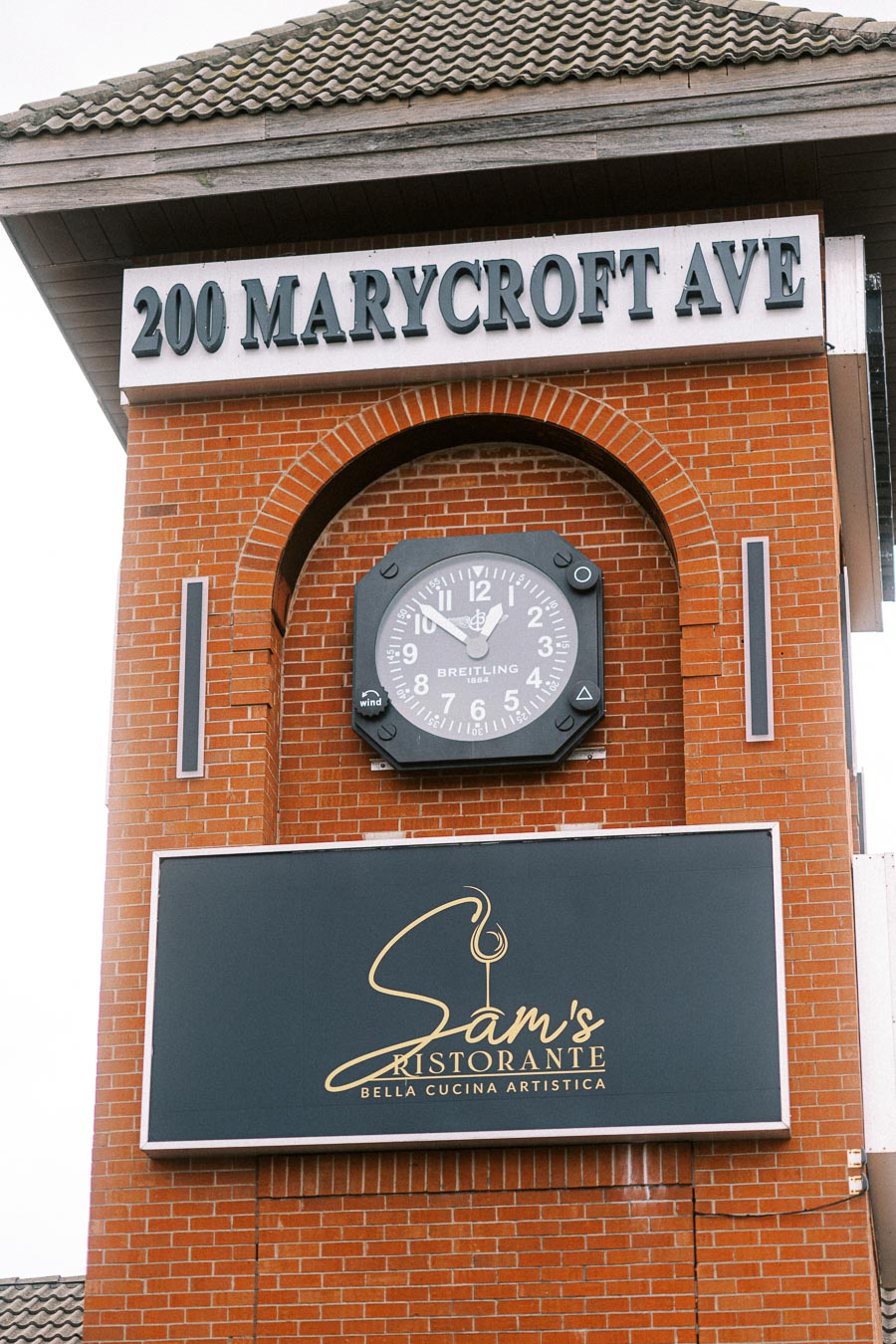 Brick building with signage for Sam's Ristorante at 200 Marycroft Ave, featuring a large clock above and the
