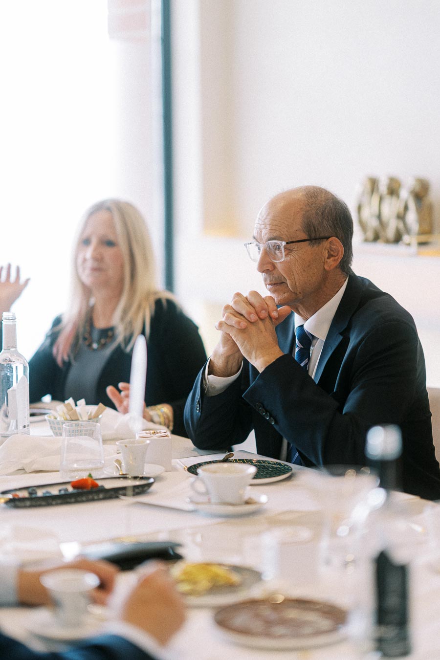 Business meeting with two professionals in formal attire seated at a conference table, engaged in discussion, with documents
