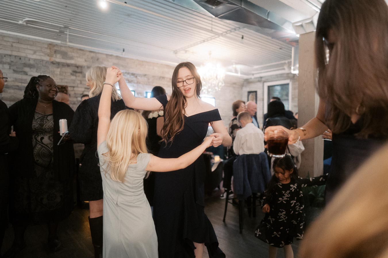 A lively party scene with people dancing and socializing in an elegantly decorated venue, highlighting a joyful and festive atmosphere.