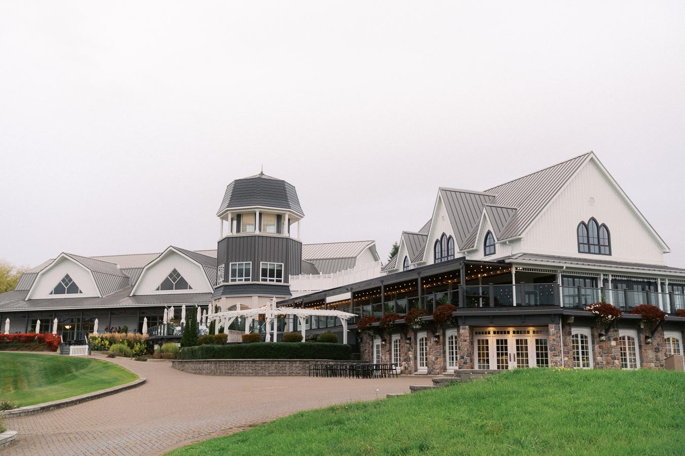Elegant resort building with a multi-level design, featuring a unique turret and large windows, surrounded by well-manicured lawns and landscaping.