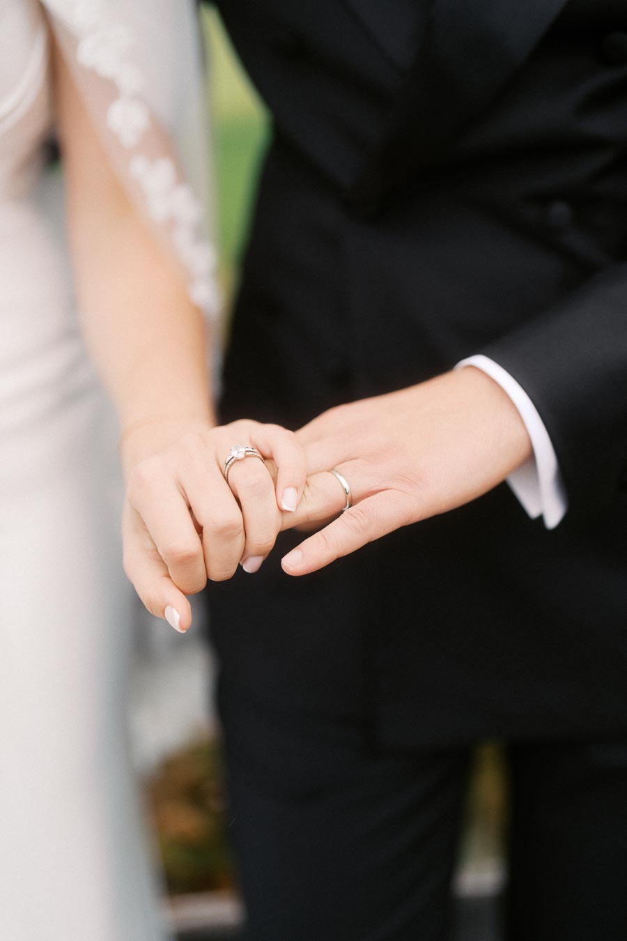 A close-up of a newlywed couple holding hands, showcasing wedding rings and symbolizing love and commitment.