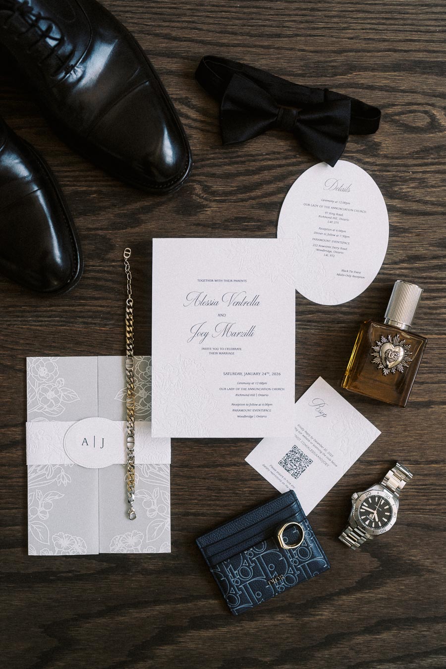 Elegant wedding flat lay with invitation, luxury perfume, bracelet, watch, leather shoes, bow tie, and wallet on wooden background.