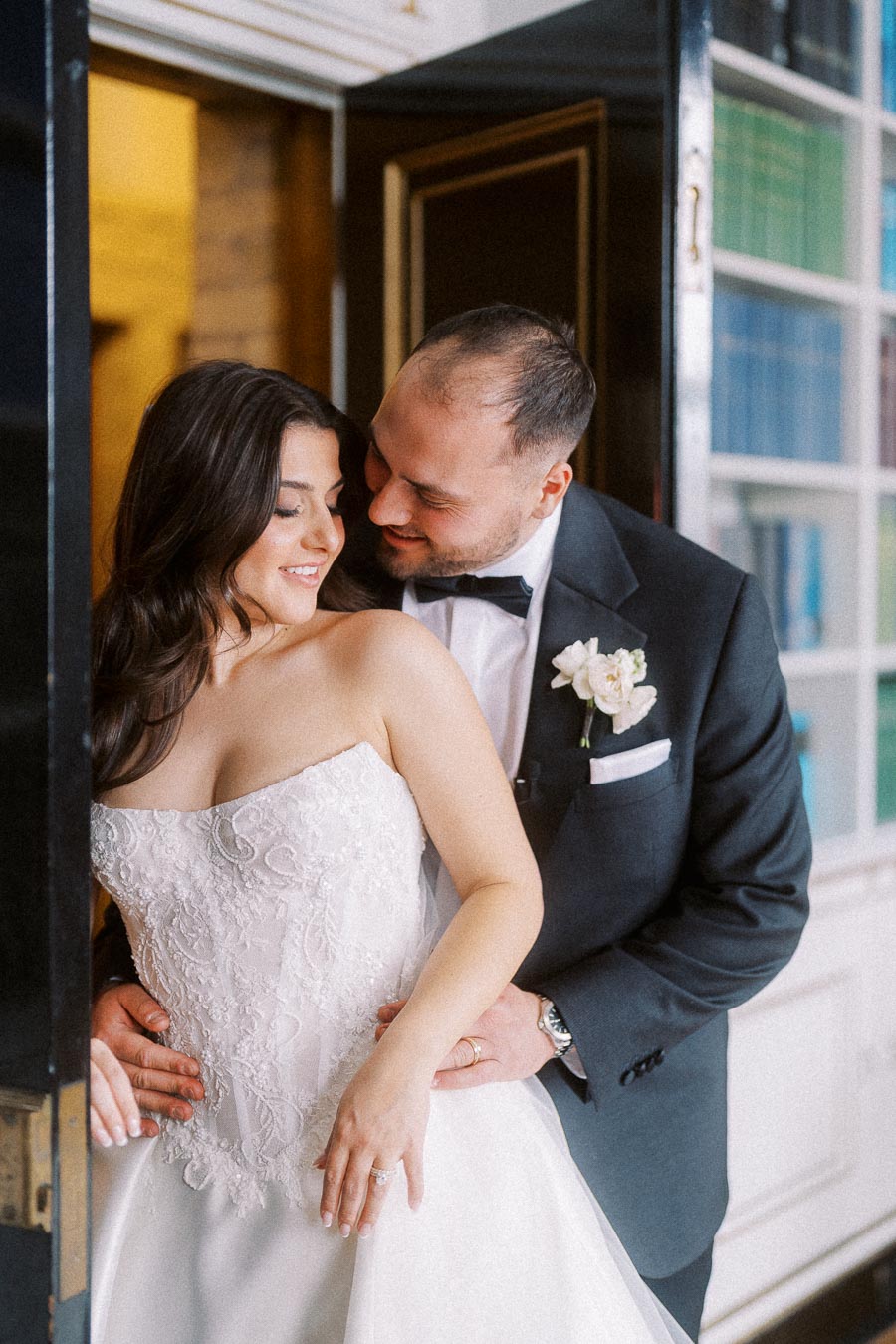 Bride and groom sharing an intimate moment on their wedding day, with the groom embracing the bride lovingly.