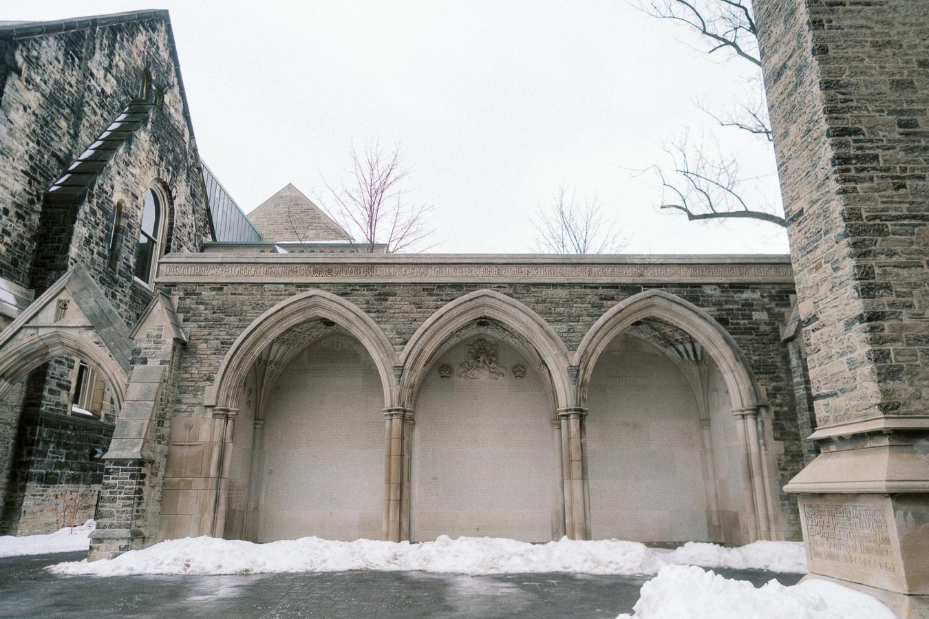 Snow-covered Gothic architecture featuring arched stone walls and intricate carvings.