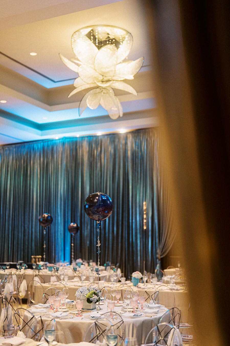 Luxurious banquet hall with elegant table settings and modern lighting fixtures.