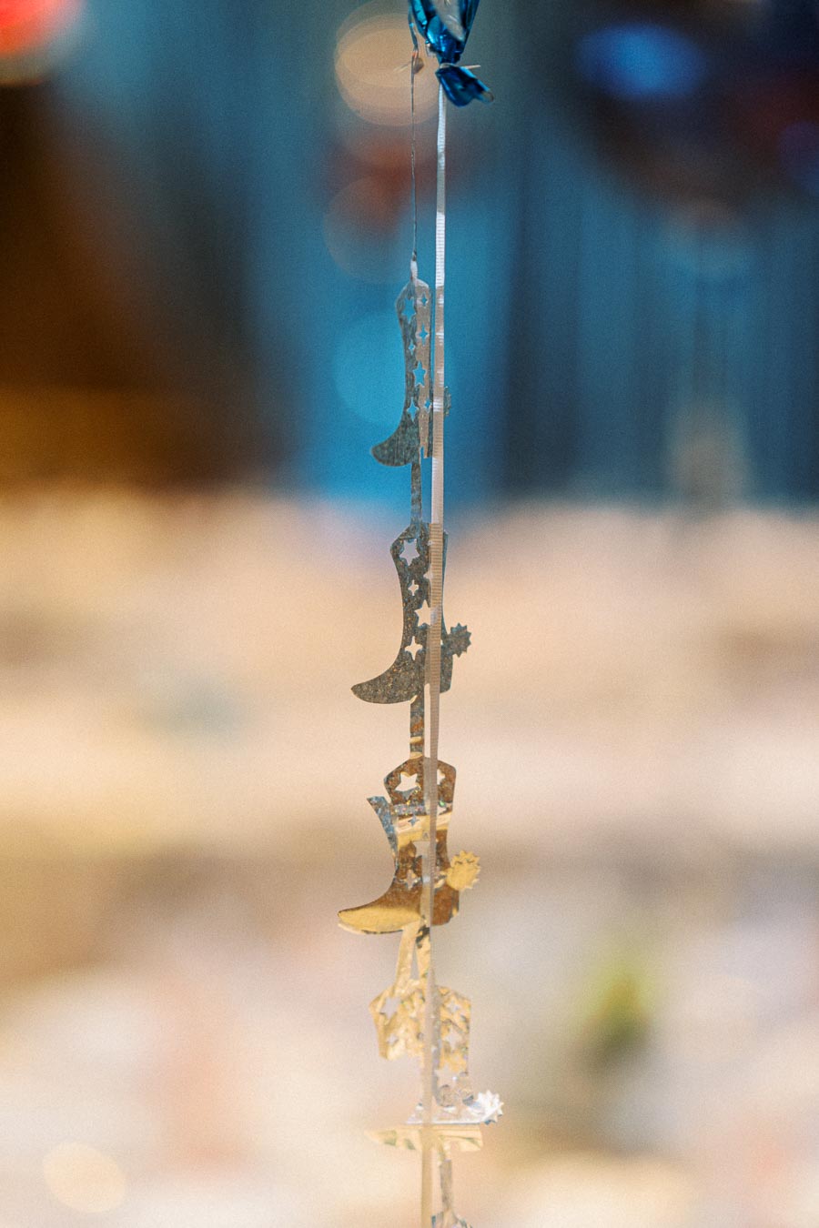 Decorative metallic cowboy boot garland with star cutouts hanging against a blurred background.