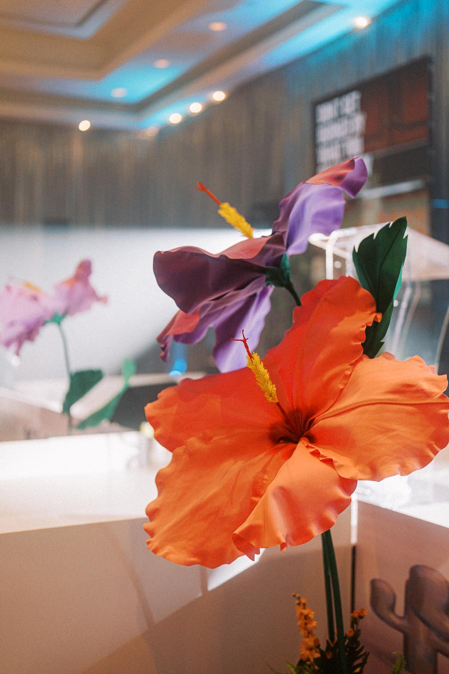 Artificial orange and purple flowers in a modern indoor setting with soft lighting.