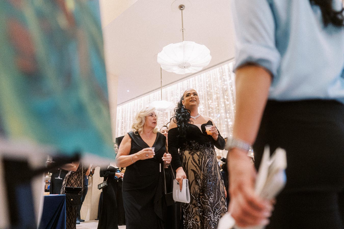 Elegant evening event with guests in formal attire, featuring decorative lighting and sophisticated ambiance.