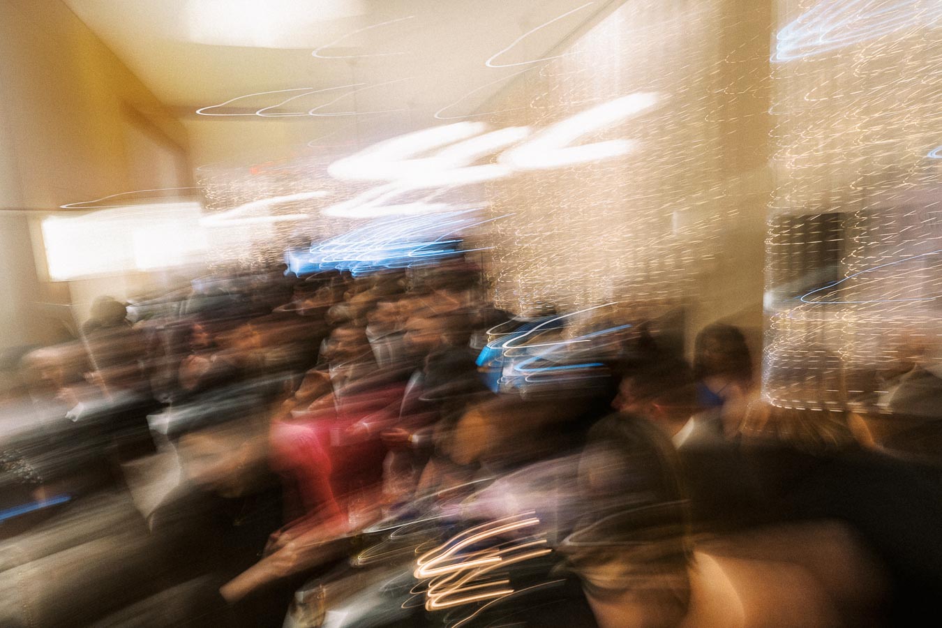 Blurred crowd at a lively indoor event with motion effects and ambient lighting.