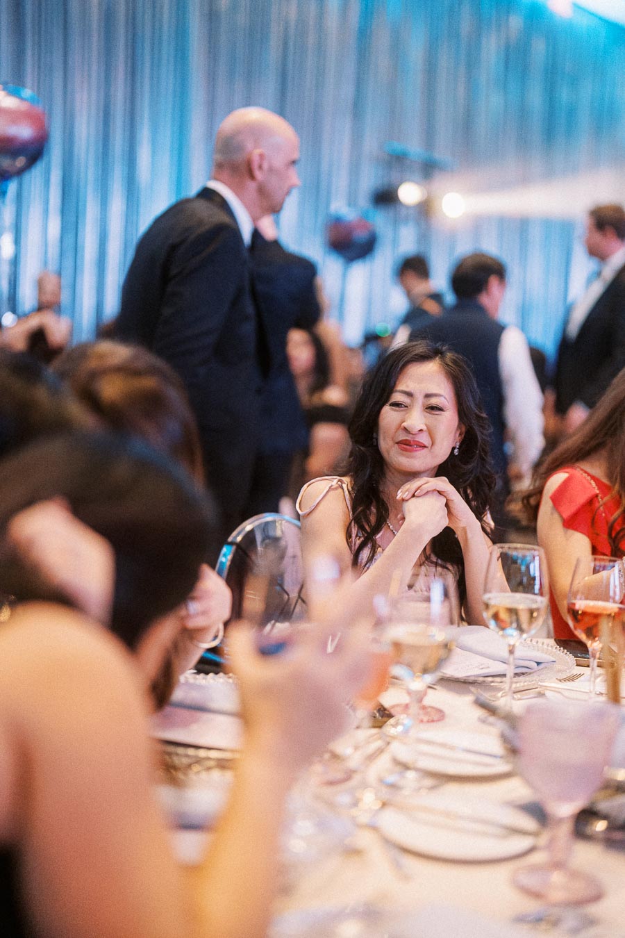 Elegant gala dinner with guests enjoying the event, featuring a beautifully decorated table with wine glasses and a lively atmosphere.