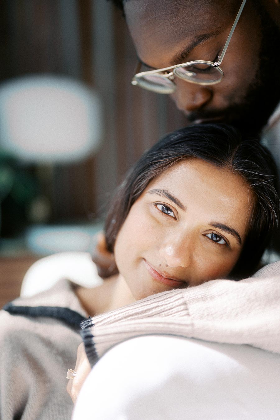 A couple sharing an intimate and tender moment, with one person resting their head contently on the other's shoulder, capturing a sense of warmth and affection.