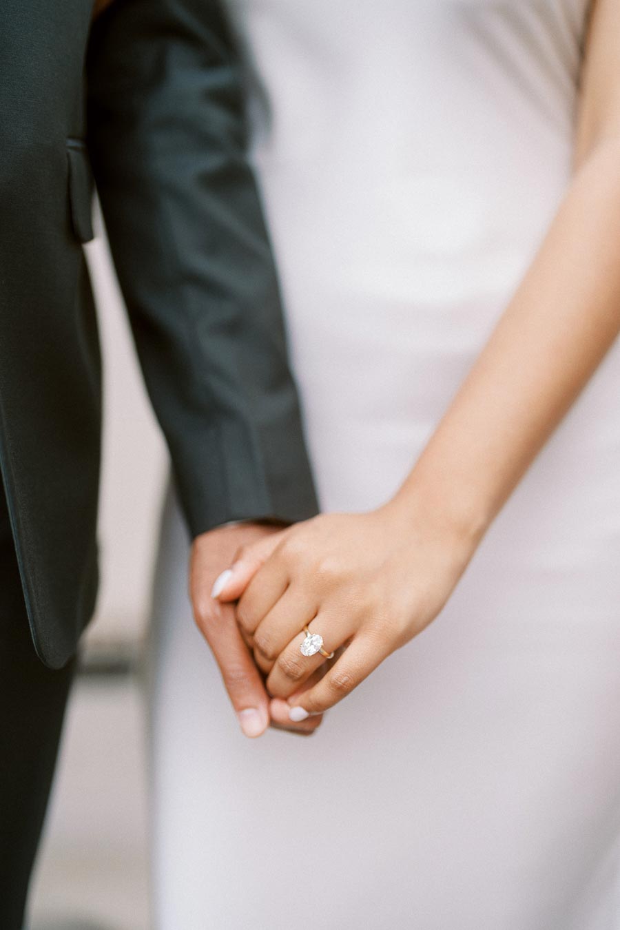 Close-up of a couple holding hands, with a focus on the engagement ring at University of Toronto.