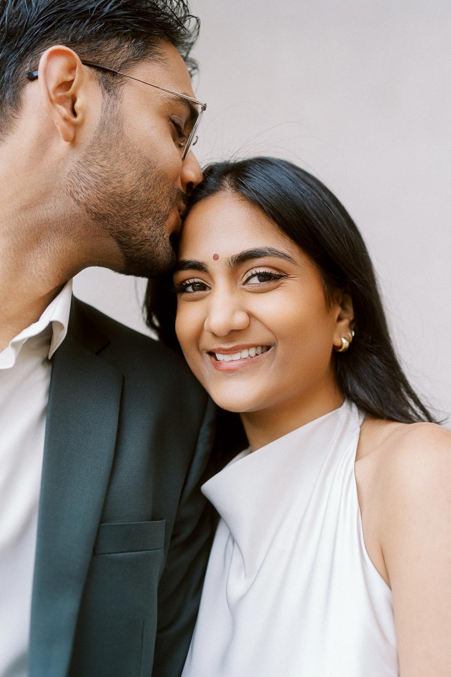 Tej kisses Priyana on the forehead as she smiles, close-up portrait at University of Toronto engagement session.