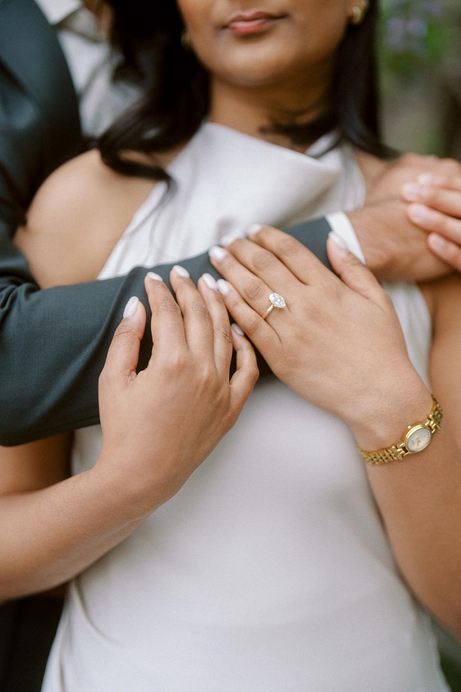Close-up of Priyana's hand with an engagement ring resting on Tej's arm during their engagement session at the University of Toronto.