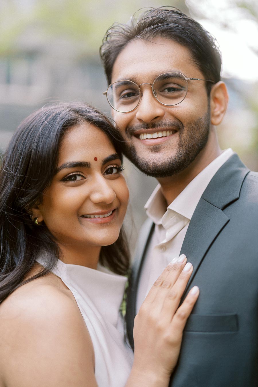Close-up portrait of Tej and Priyana smiling together during their engagement session at the University of Toronto campus.