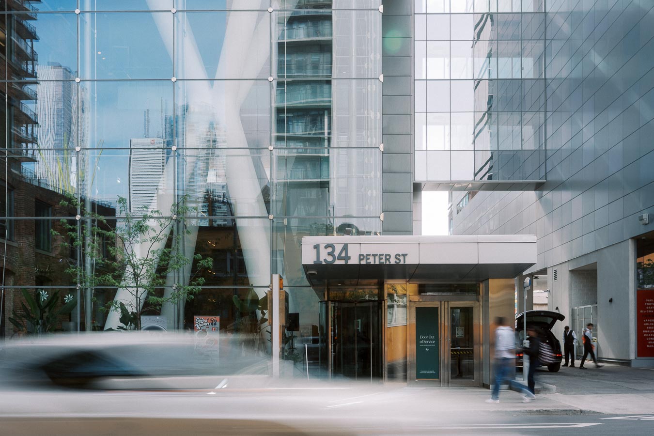 Street view of 134 Peter Street entrance at Ricarda’s, Toronto, with glass facade and people arriving for the Toronto Prep Forever Launch Party event.