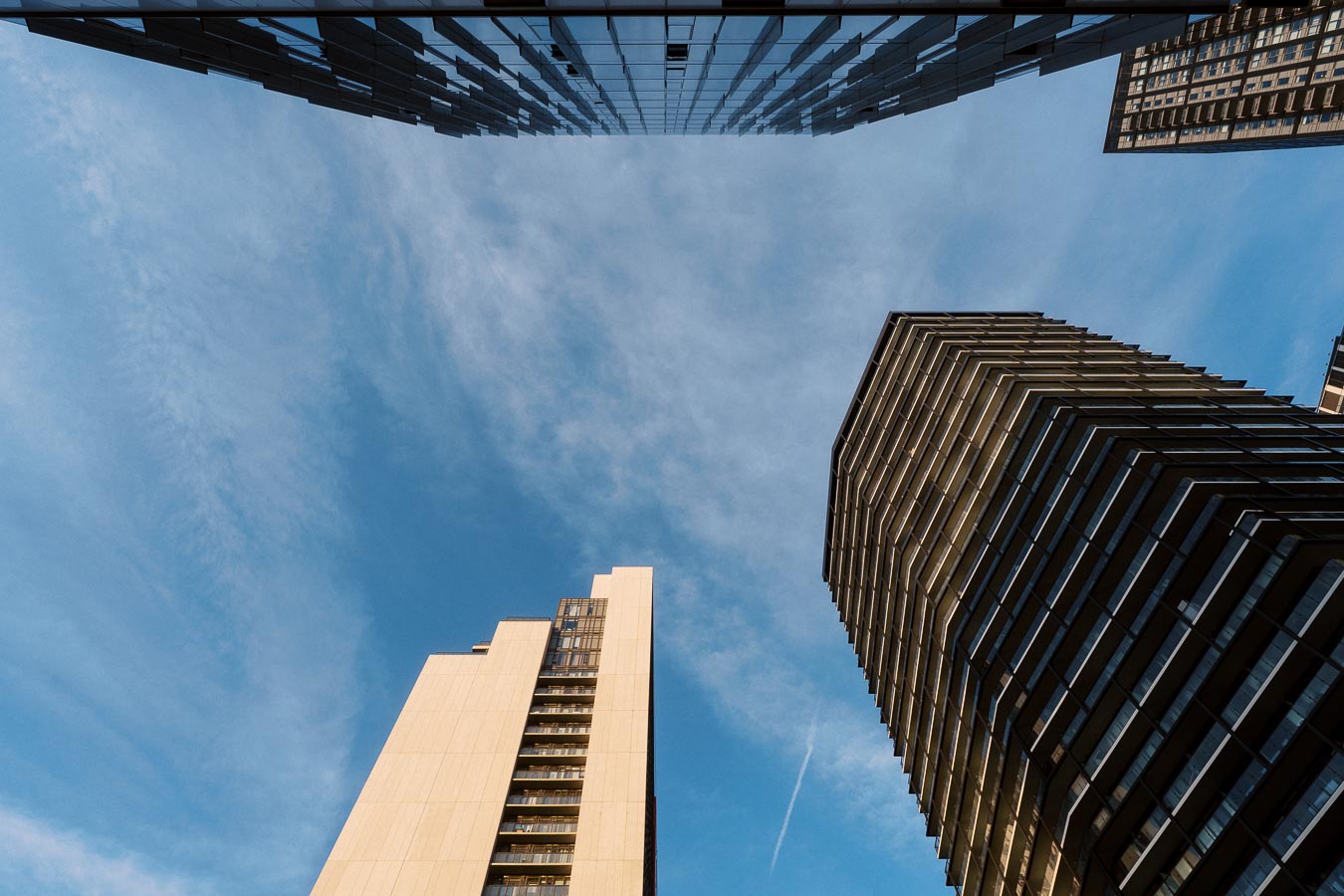 View looking up at modern high-rise buildings surrounding a blue sky near Ricarda's Restaurant in downtown Toronto.