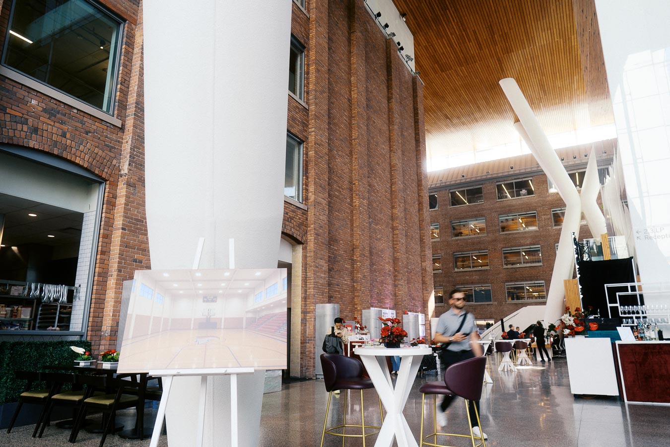 Wide view of Ricarda’s Atrium in Toronto with modern brick walls, high ceilings, event tables, and Toronto Prep School branding on display.