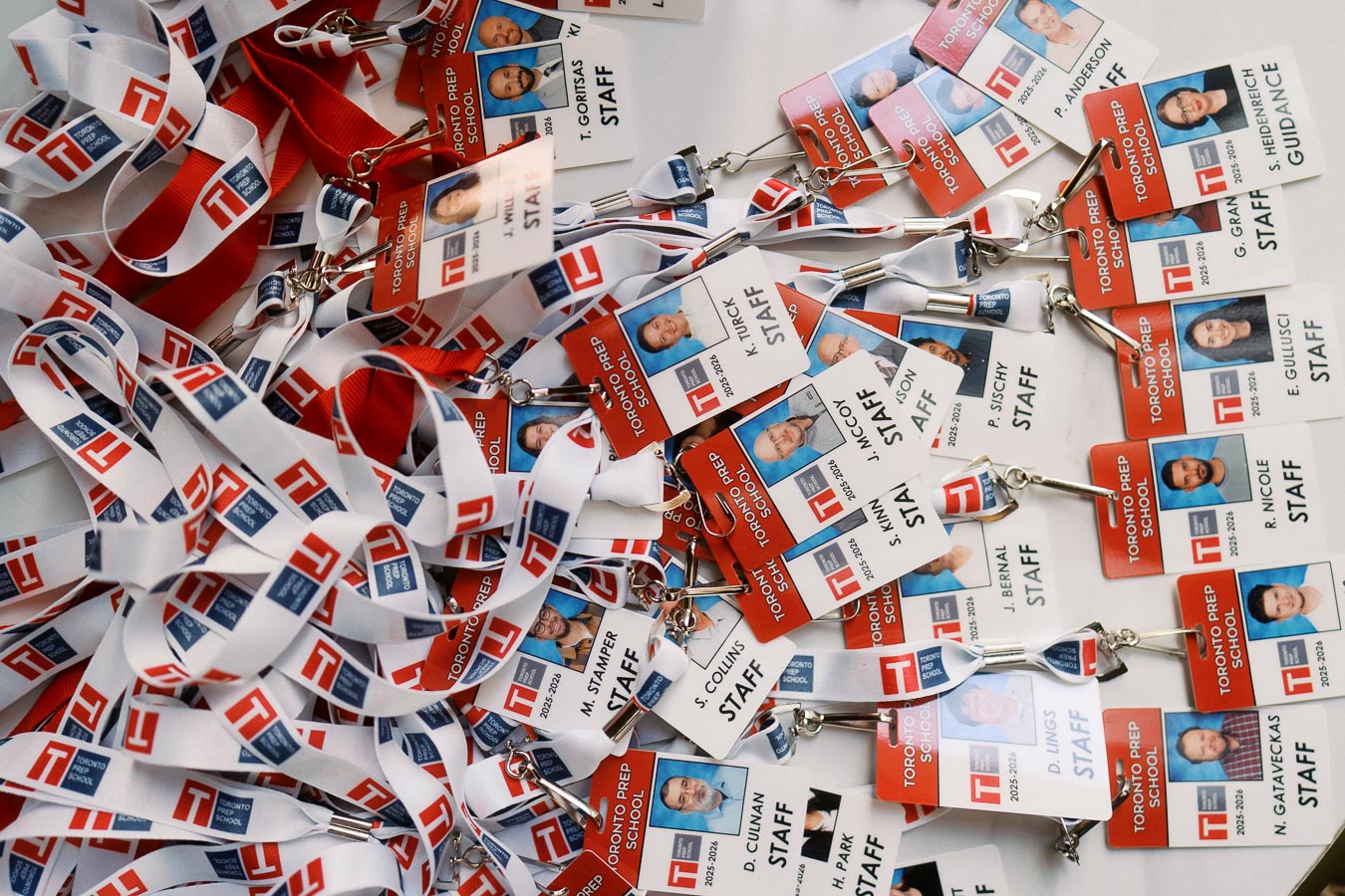 A pile of Toronto Prep School staff lanyards and photo ID badges arranged on a table at Ricarda’s during the Forever Launch Party in Toronto.