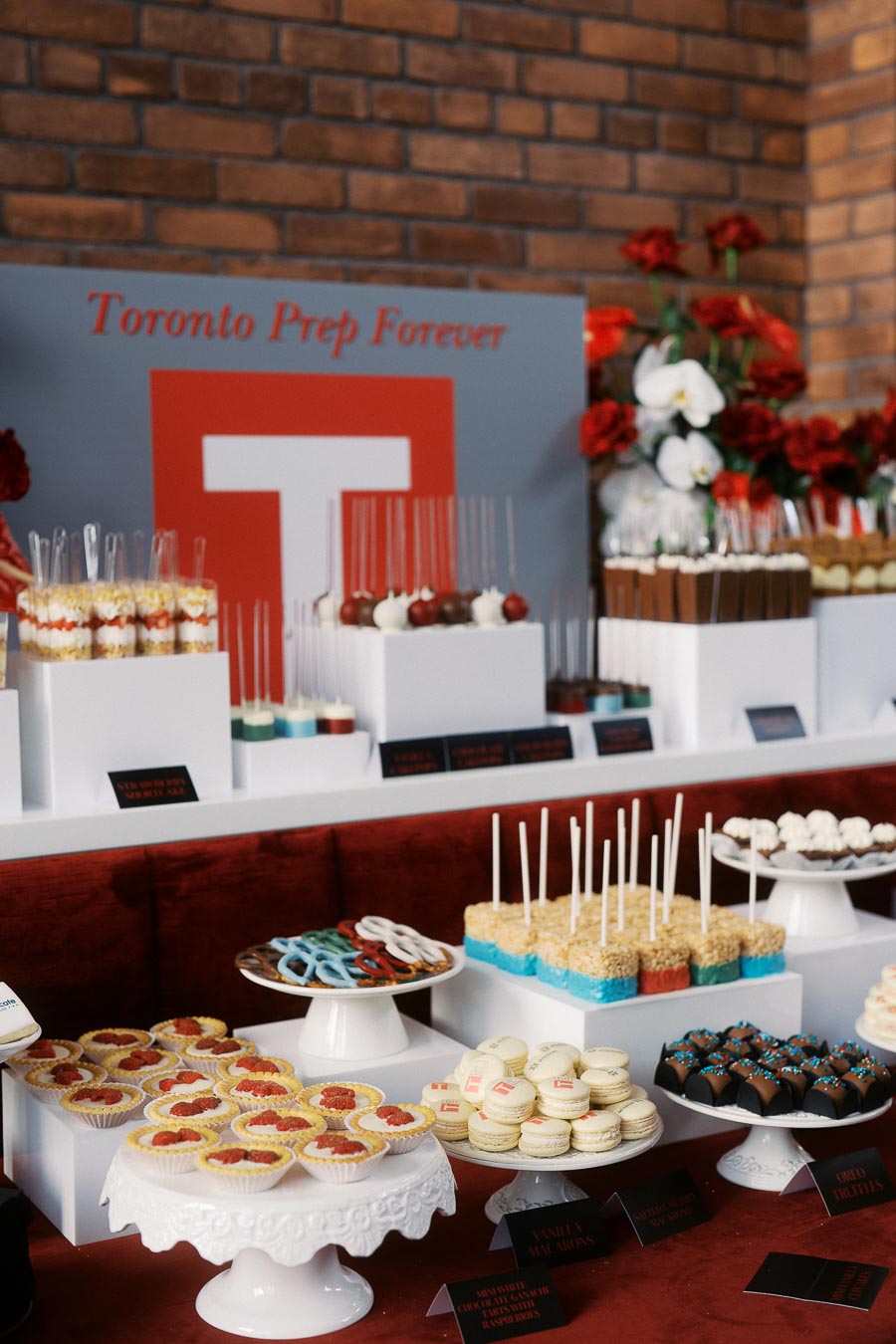 Dessert table with Toronto Prep School branding, assorted sweets, and pastries at the Toronto Prep Forever Launch Party at Ricarda’s in Toronto.