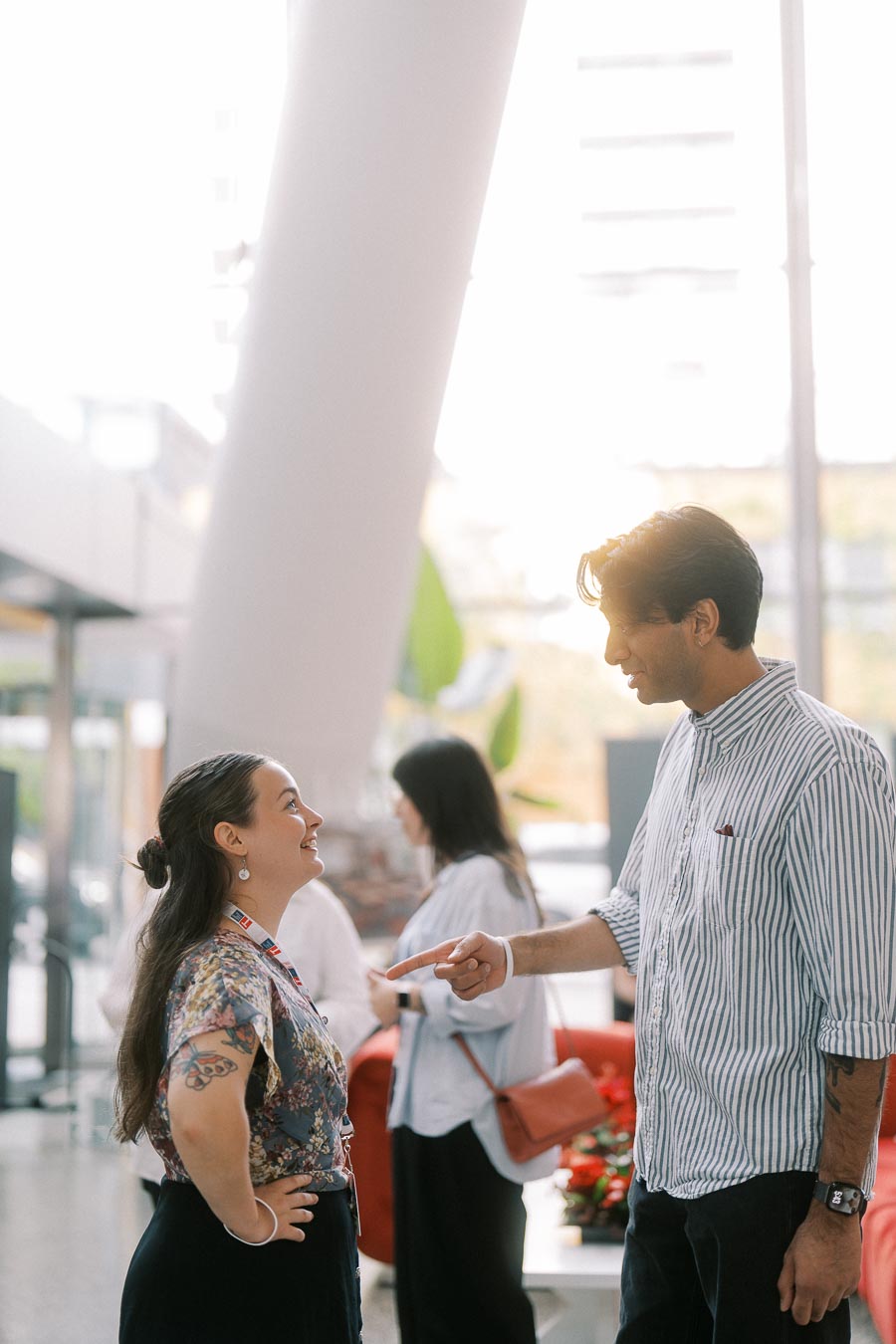 Two adults stand facing each other in animated conversation at The Atrium at Ricarda’s during the Toronto Prep Forever Launch Party, with other attendees and event decor visible in the background.