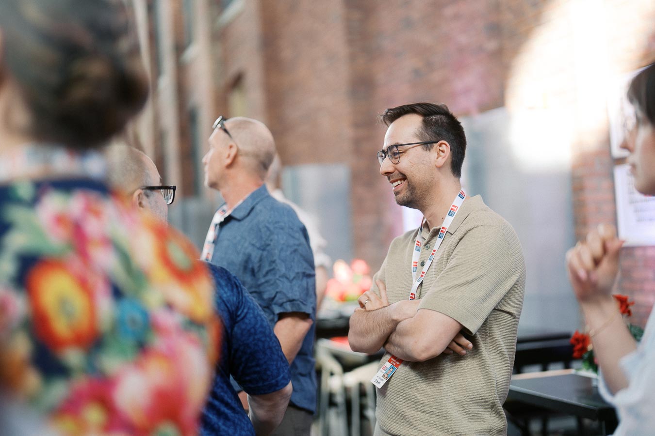 Guests in conversation at the Toronto Prep Forever Launch Party, with a man smiling and wearing a lanyard, inside Ricarda’s Toronto event space.