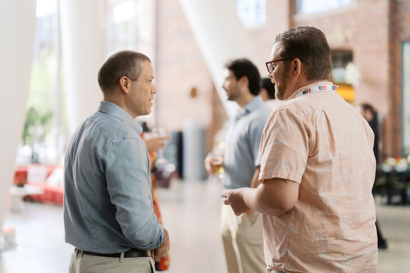 Two men in conversation at the Toronto Prep Forever Launch Party at The Atrium at Ricarda’s, with other attendees networking in the background.