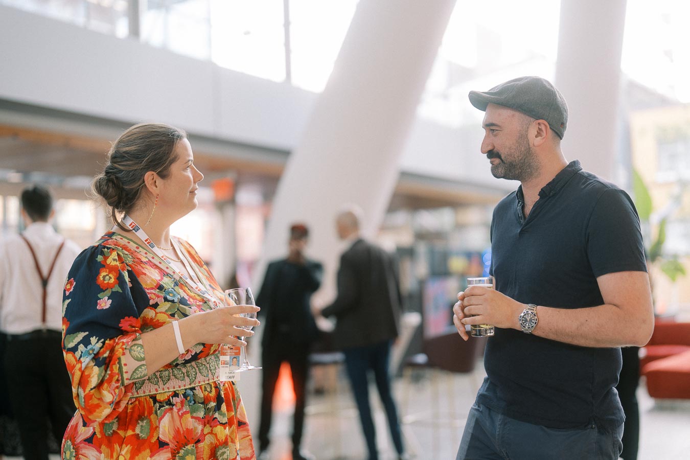 A woman in a floral dress and a man in a cap chat while holding drinks at the Toronto Prep Forever Launch Party inside Ricarda’s, Toronto.