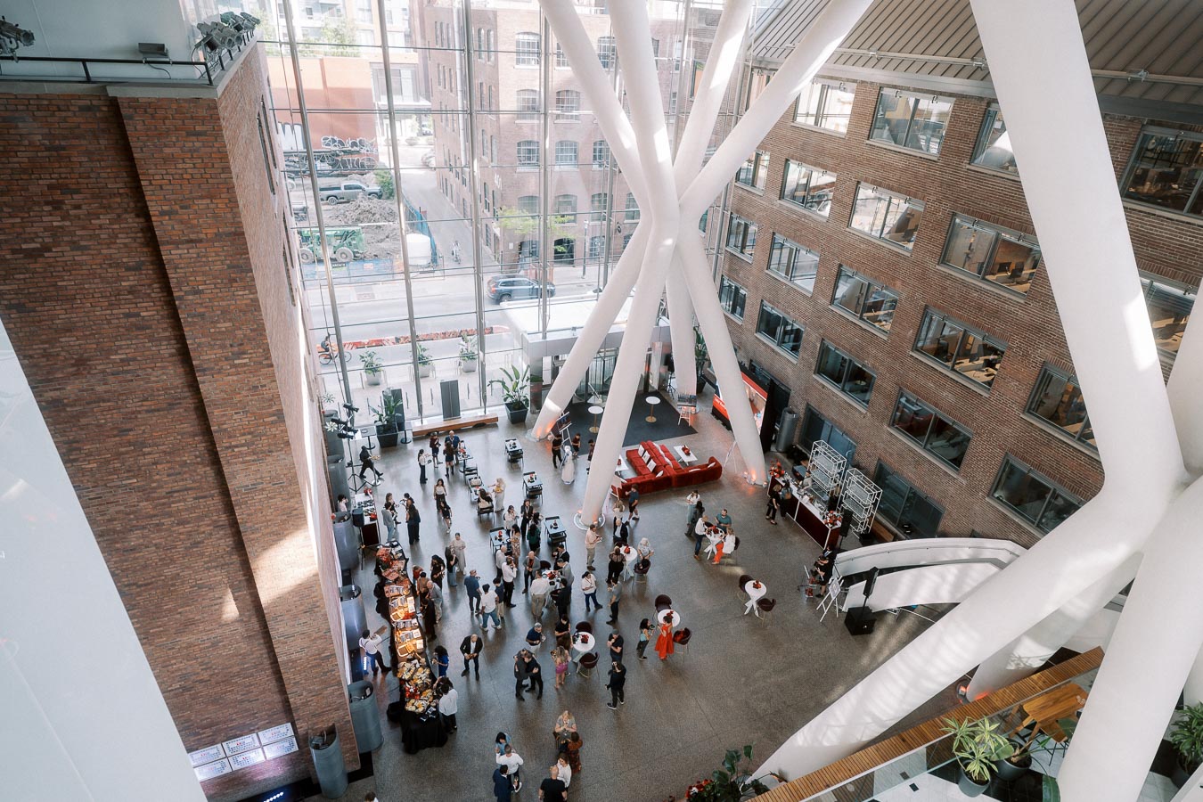 Overhead view of guests mingling in the bright, modern atrium of Ricarda’s Toronto during the Toronto Prep Forever Launch Party, with visible buffet and seating areas.