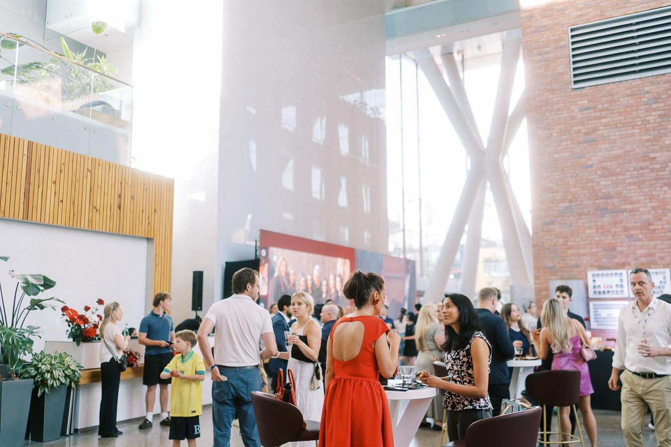 Guests socializing at high-top tables in the sunlit Atrium at Ricarda’s, Toronto, during the Toronto Prep Forever Launch Party event.