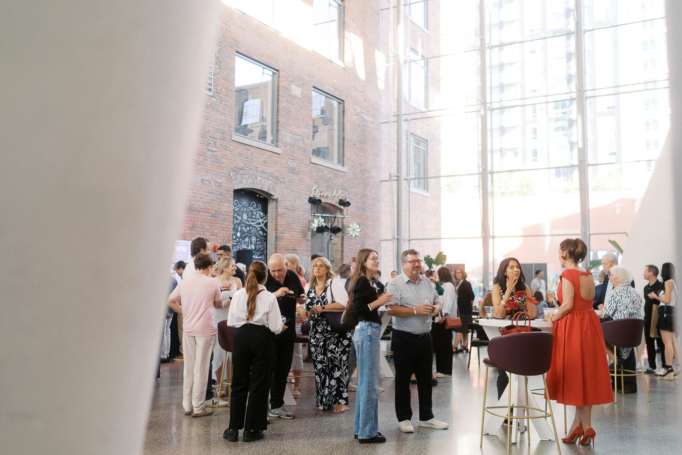 Guests gather in the modern, sunlit Atrium at Ricarda’s, Toronto, during the Toronto Prep Forever Launch Party, engaging in conversation and networking.
