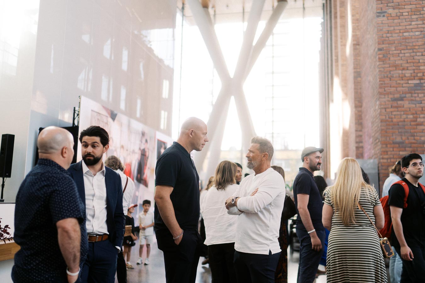 Groups of adults and children networking and talking in the bright, modern atrium of Ricarda’s during the Toronto Prep Forever Launch Party in Toronto.