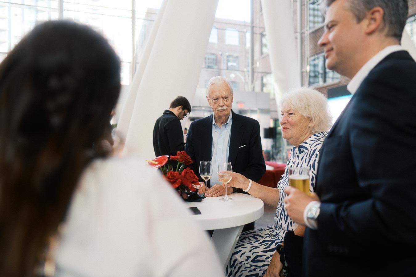 A group of guests gather around a cocktail table with drinks and flowers at Ricarda’s during the Toronto Prep Forever Launch Party in Toronto.