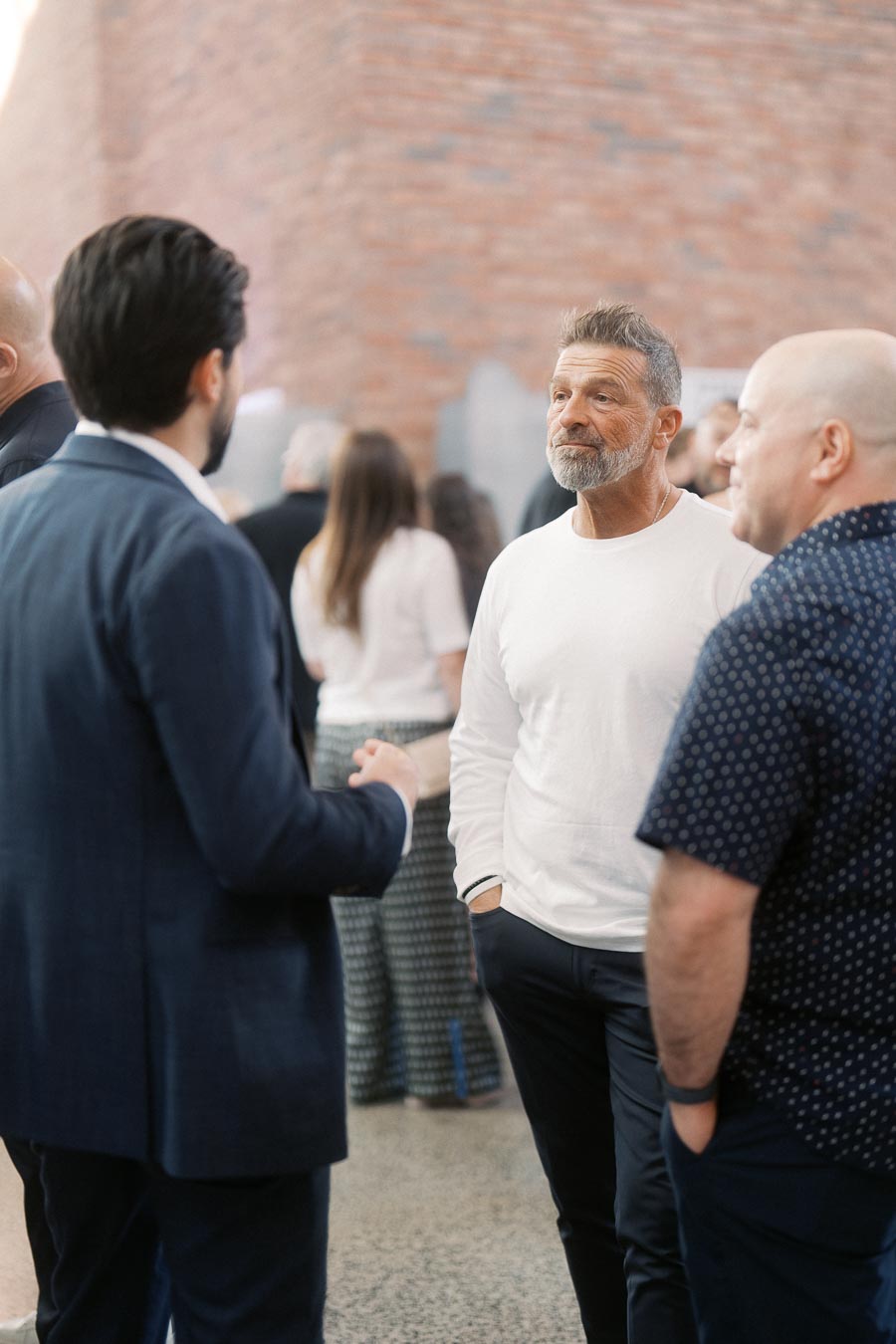 Three men in conversation at the Toronto Prep Forever Launch Party, set against a brick wall inside The Atrium at Ricarda’s, Toronto.