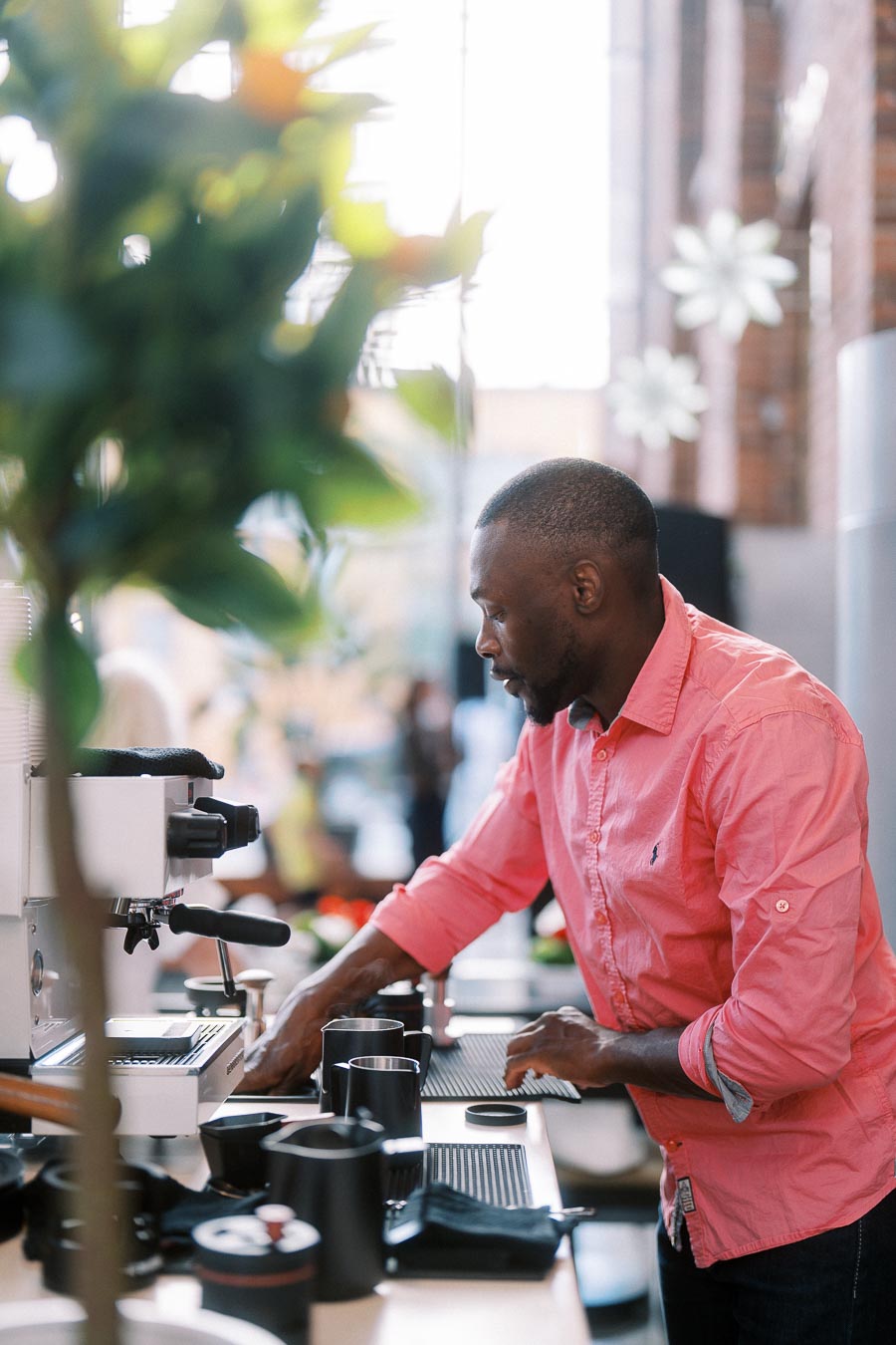Barista in a pink shirt prepares coffee at an espresso machine during the Toronto Prep Forever Launch Party at Ricarda’s, Toronto.