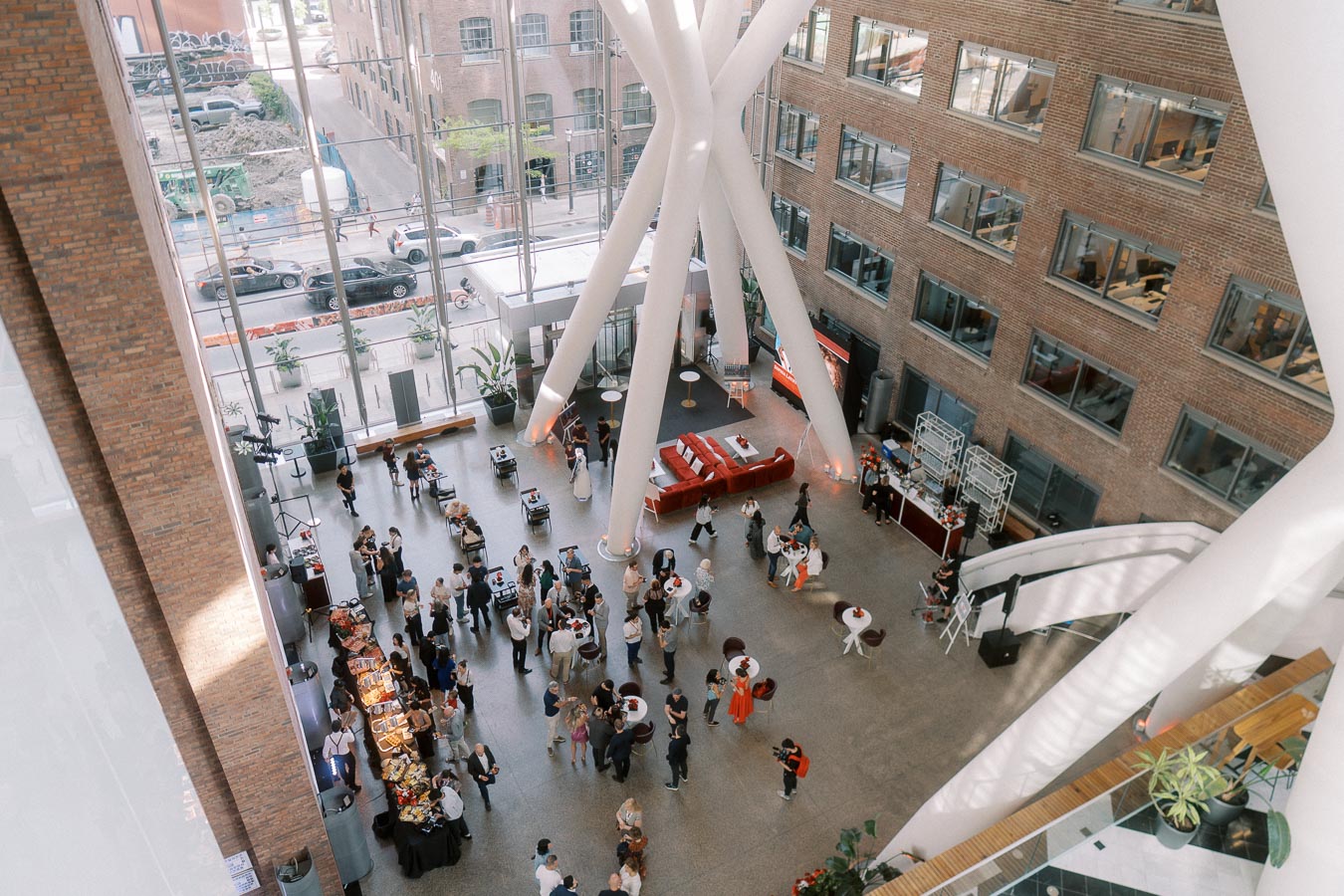 Overhead view of guests mingling in the modern glass Atrium at Ricarda’s, Toronto, during the Toronto Prep Forever Launch Party, with visible food stations and event decor.