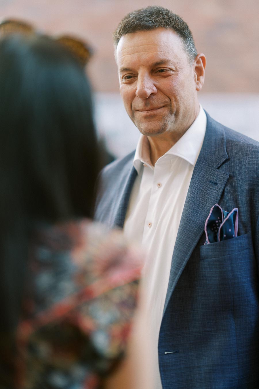 A man in a blue suit and white shirt listens to another guest during the Toronto Prep Forever Launch Party at Ricarda’s in Toronto.