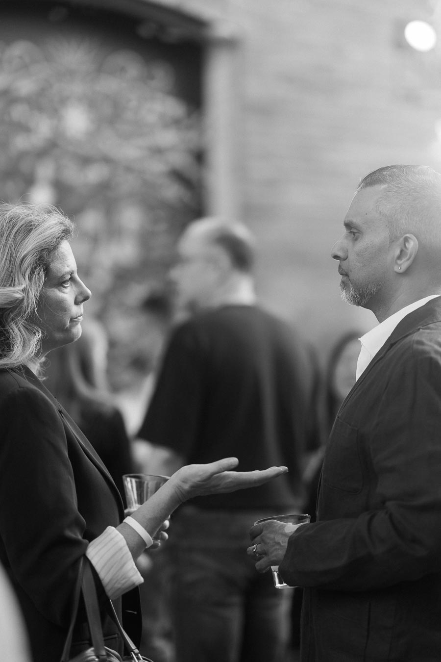 Two adults in conversation at the Toronto Prep Forever Launch Party at Ricarda’s in Toronto, holding drinks, with blurred attendees in the background.