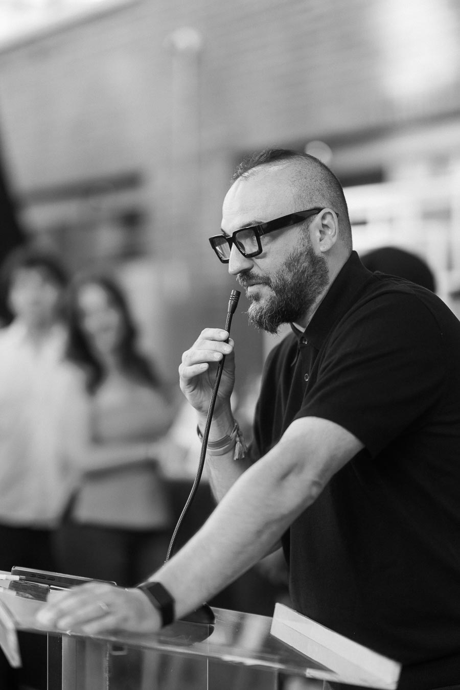 A man with glasses and a beard speaks into a microphone at a podium during the Toronto Prep School launch event at Ricarda's in Toronto.