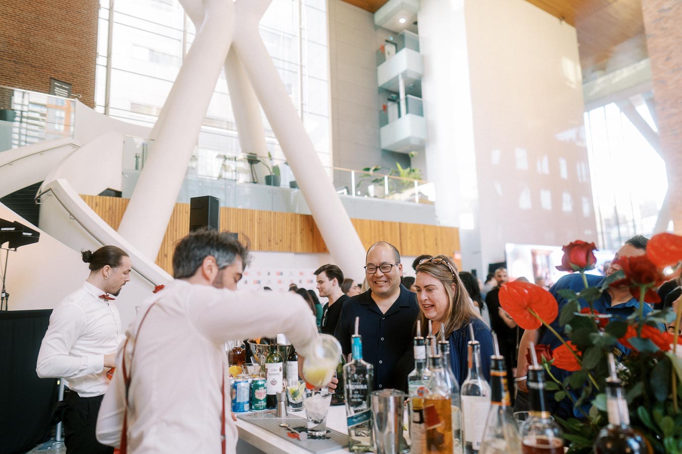 Bartender pouring drinks for smiling guests at a modern bar during the Toronto Prep Forever Launch Party at Ricarda’s in Toronto.