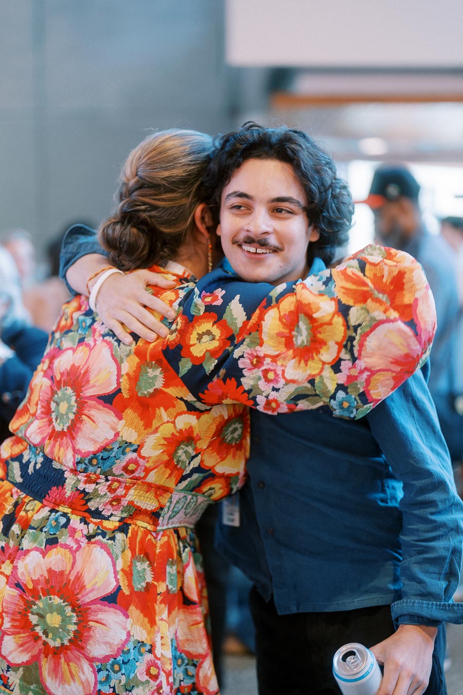 A young man and a woman in a floral dress share a warm hug at the Toronto Prep Forever Launch Party at Ricarda’s in Toronto.