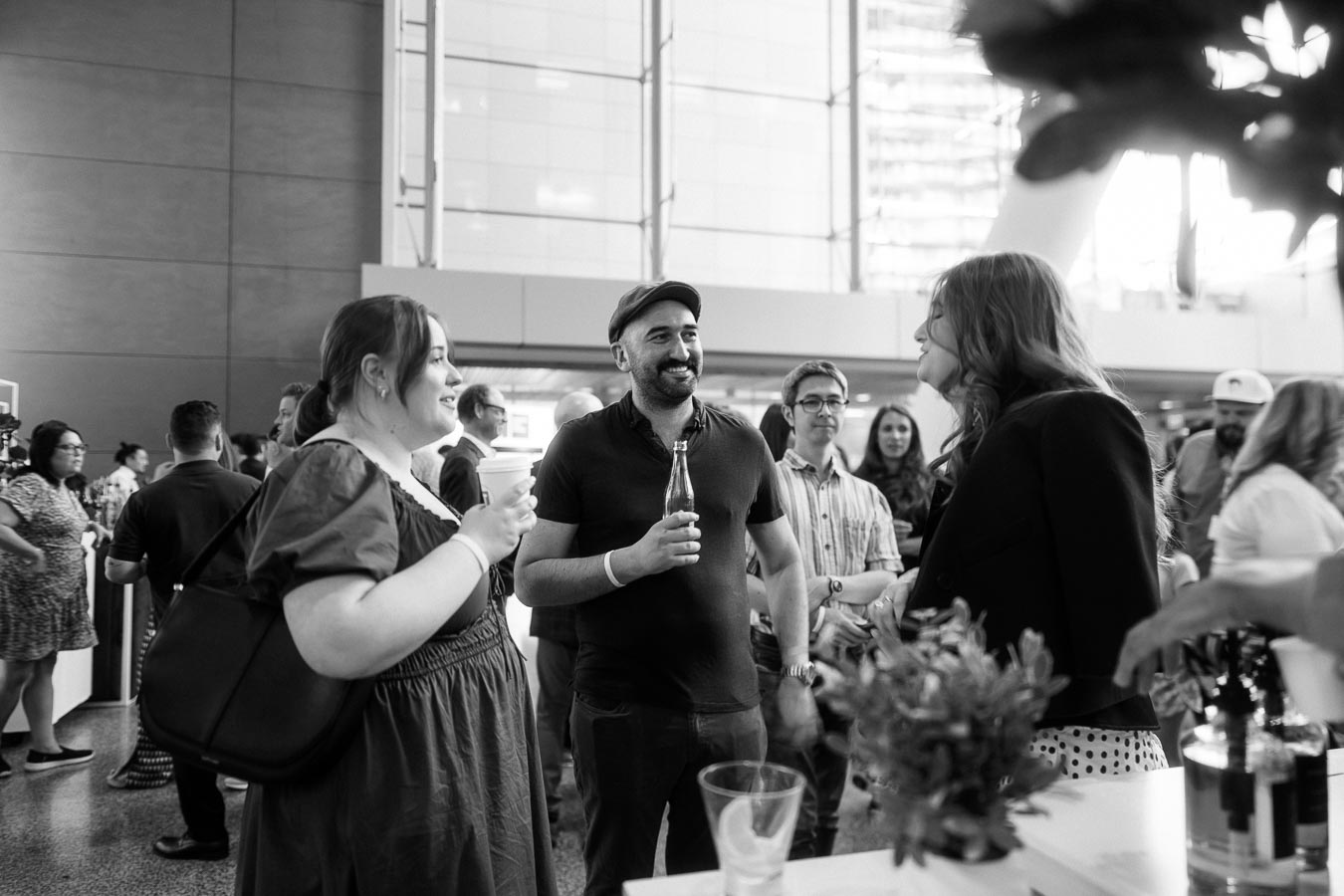 A group of guests socializing and holding drinks at the Toronto Prep Forever Launch Party at Ricarda’s, Toronto, in a modern atrium setting.