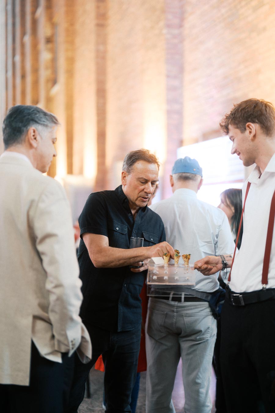 A guest in a black shirt selects hors d’oeuvres from a tray served by a staff member at Ricarda’s during the Toronto Prep Forever Launch Party.