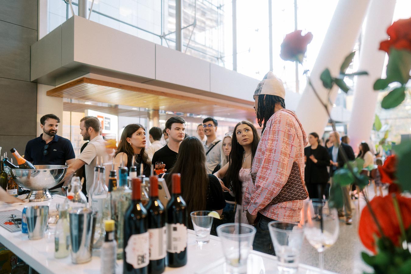Guests gathered by the bar at Ricarda’s Toronto, talking and socializing during the Toronto Prep Forever Launch Party, with bottles and glasses visible in the foreground.